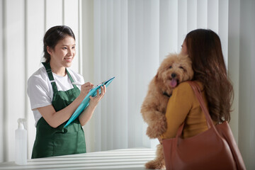 Here's an alt tag for the image: `Pet groomer taking appointment from client`